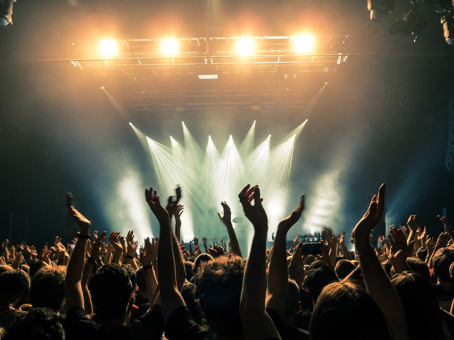 Concert-crowd-with-silhouettes-of-people-hold-their-hands-up